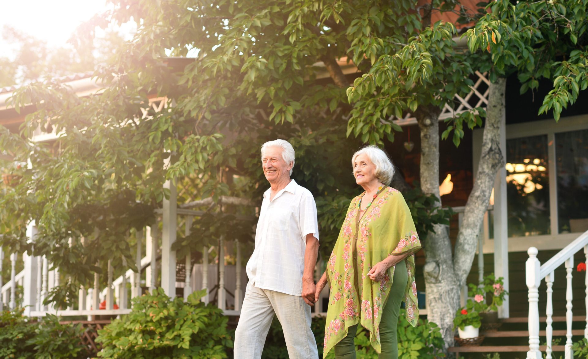 a beautiful elderly couple walks near their house