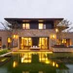 facade of modern building near pond at dusk