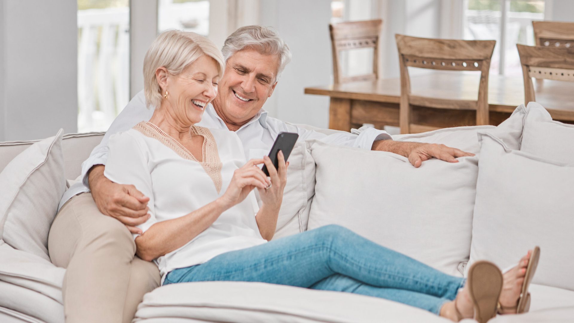 Funding Seasoned Investors looking at a mobile phone together on the sofa