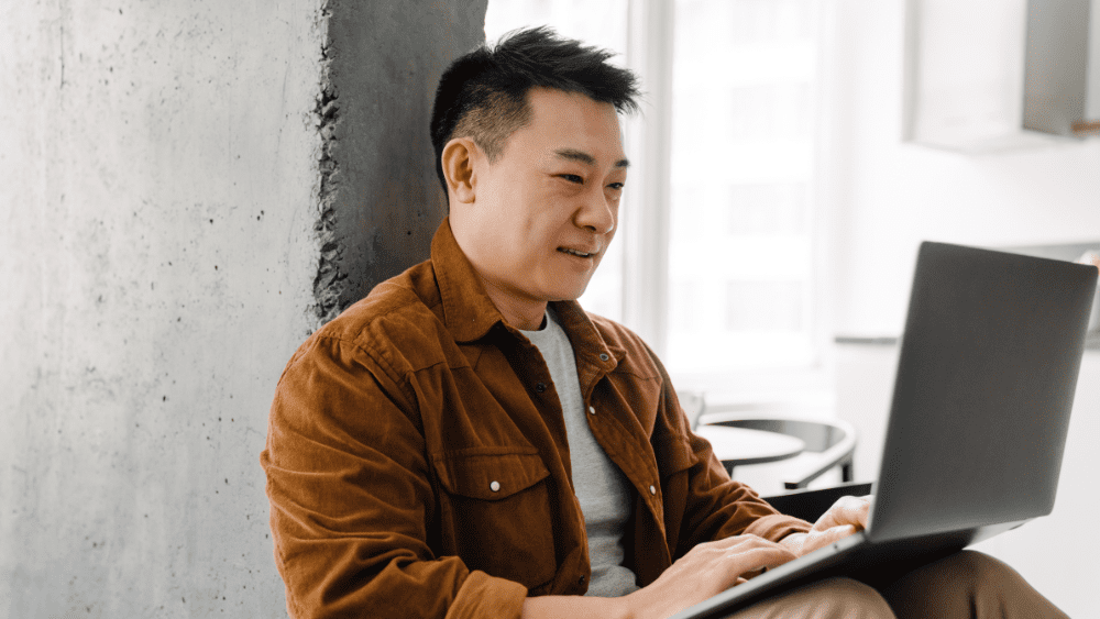 A man sitting down in front of his laptop - Funding