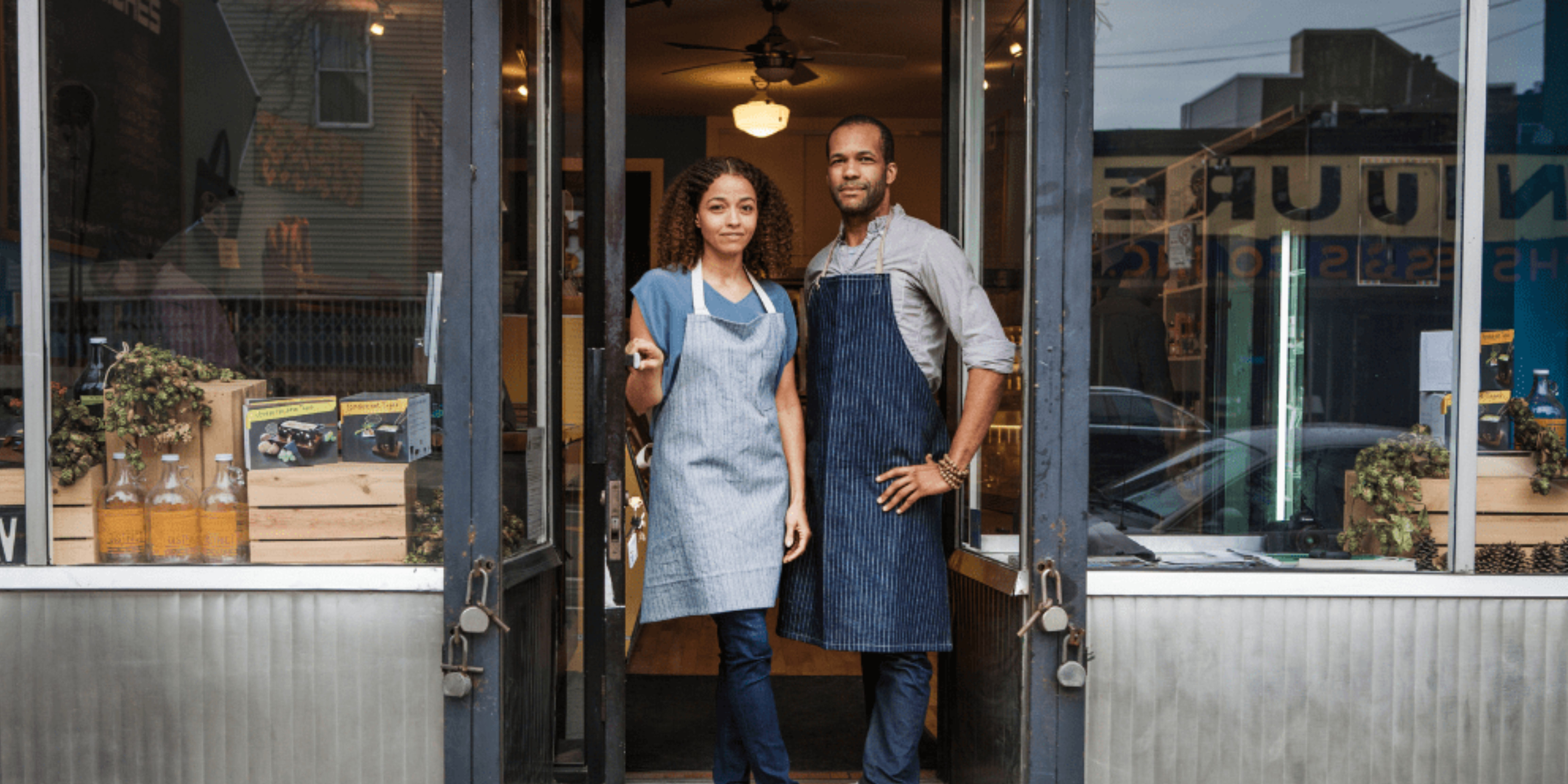 Two people standing in front of a shop