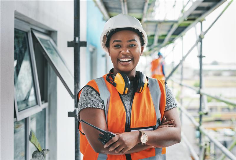 A builder wearing protective clothing standing inside a construction site